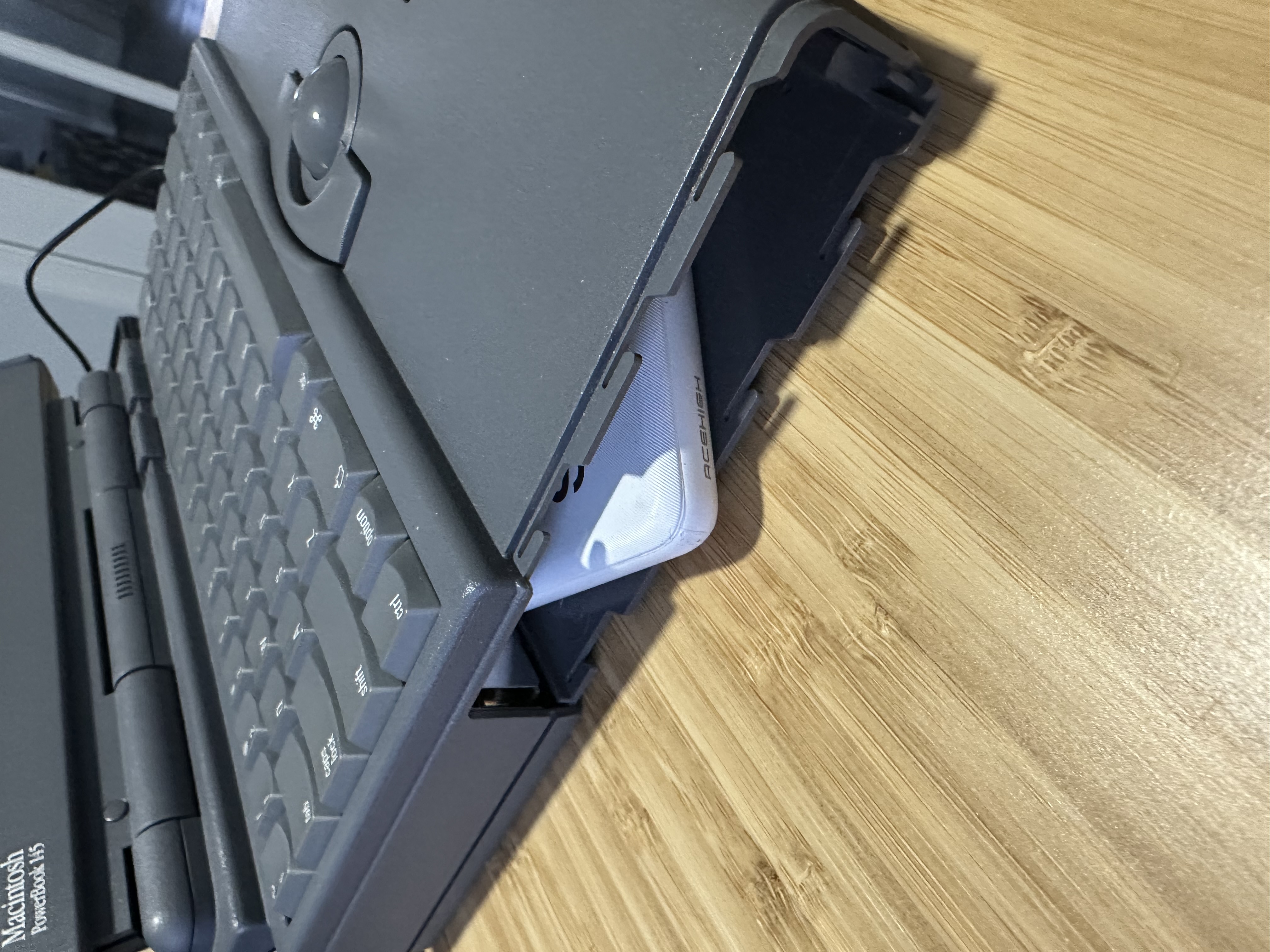 Flat USB cable routed toward the PowerBook battery bay for external BlueSCSI power